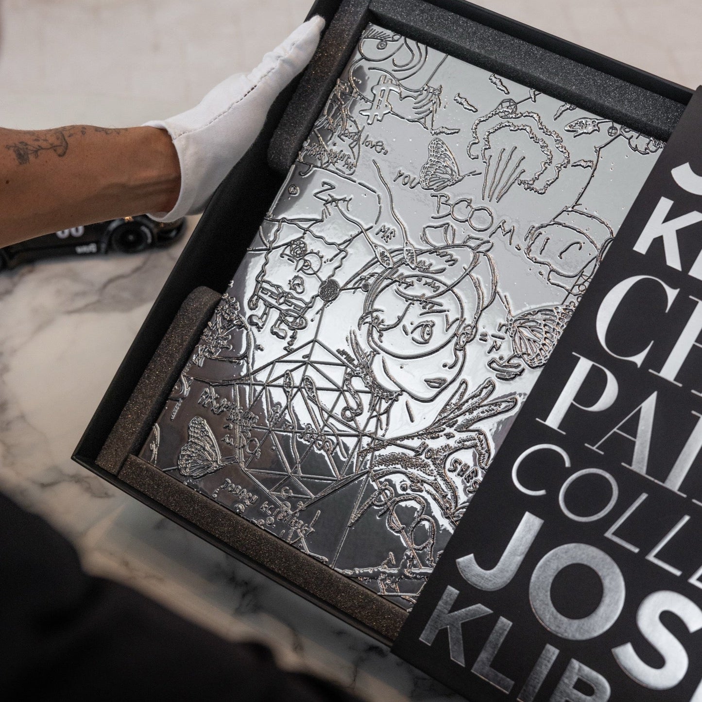 Person holding a chrome painting collectable art collectable by Joseph Klibansky in a black box