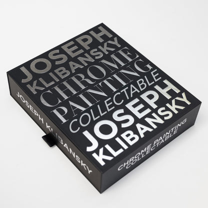 A black box with chrome foil silver text on it, by Joseph Klibansky chrome painting collectible in its closed position on a white background.