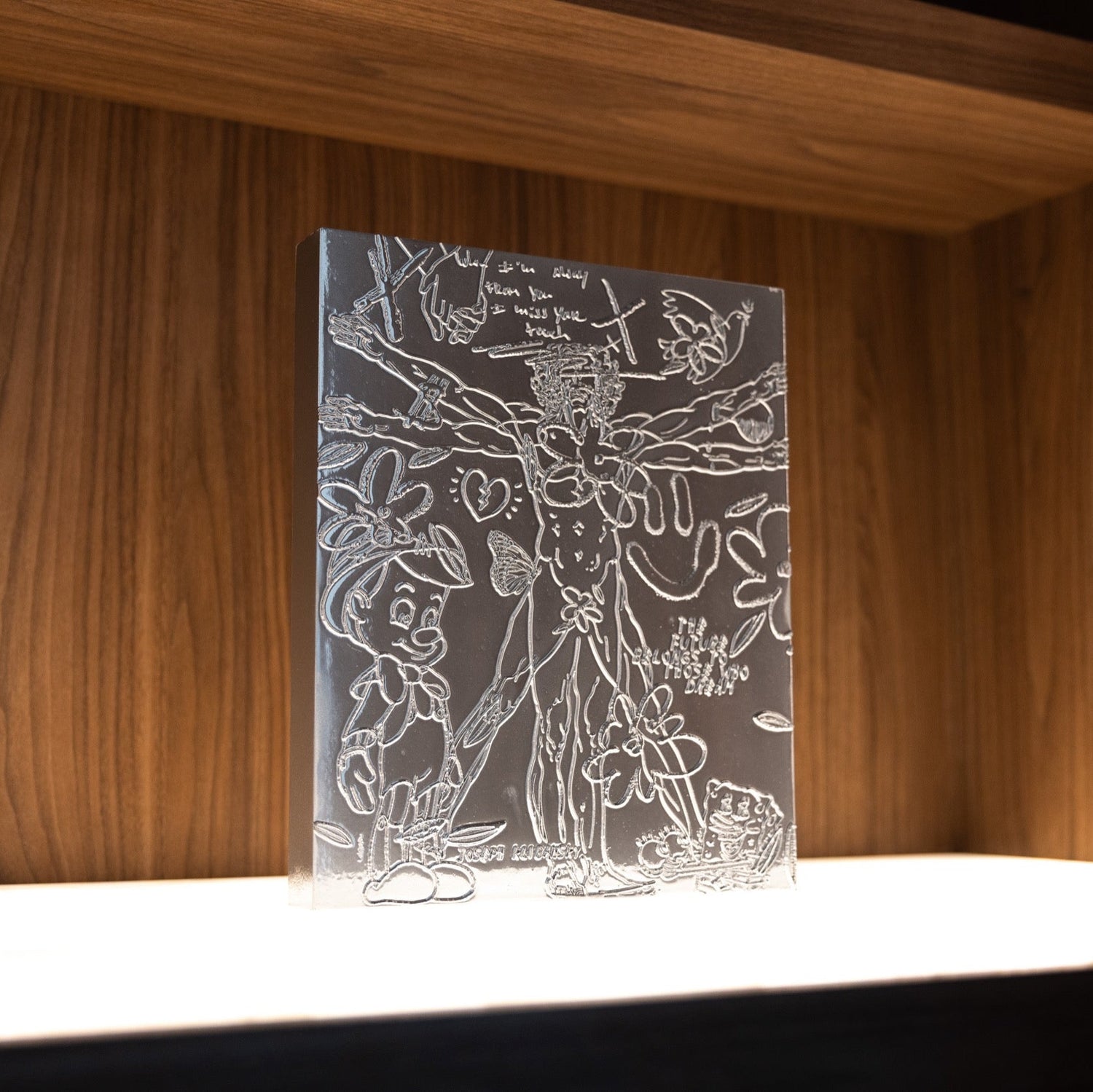 An artwork by Joseph Klibansky, The Chrome Painting Collectible, a standalone artwork silver colour relief painting engravings standing in a shelf